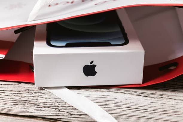 iPhone 12 retail box partially visible inside a shopping bag