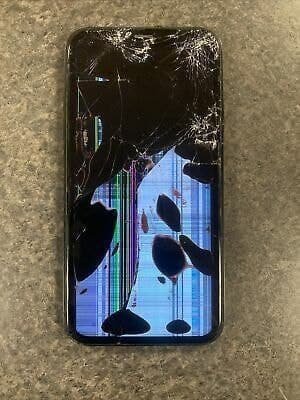 Severely cracked iPhone screen with large black spots and display dimming